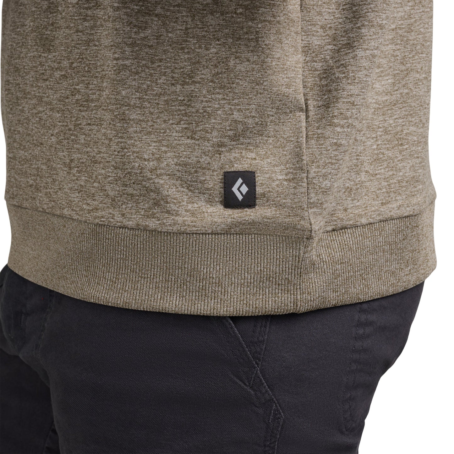 Close-up of a beige hoodie with a brand logo on a white background