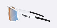 Load image into Gallery viewer, White sunglasses with black arms on a light gray background, featuring the BLIZ brand.