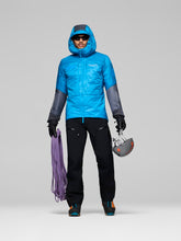 Load image into Gallery viewer, Person wearing a blue jacket with black sleeves and pants, holding climbing equipment on a gray background