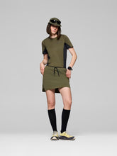 Load image into Gallery viewer, Person wearing a green outfit with black accents on a gray background