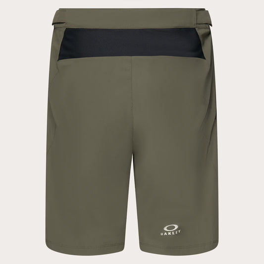 Olive green Oakley athletic shorts with a black contrast waistband panel and a small white Oakley logo near the lower left leg, shown on a light gray background.