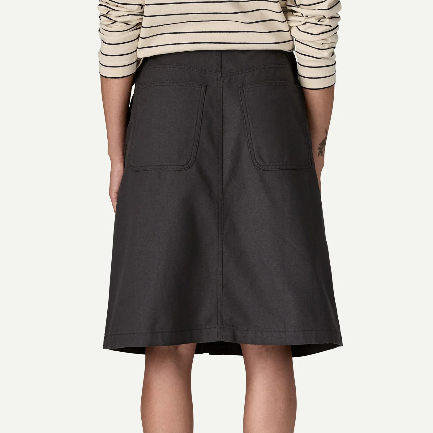 Person wearing a black skirt with a white background