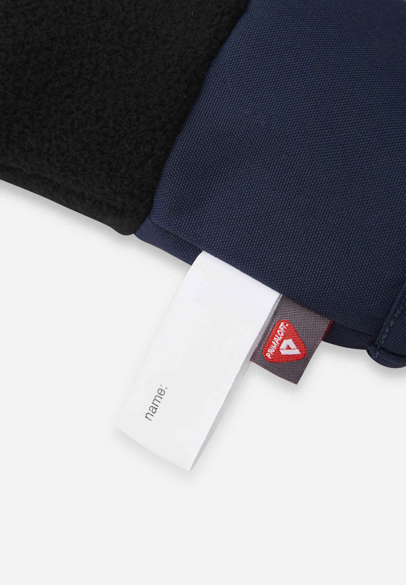 Close-up of a navy blue garment with a visible brand tag on a white background