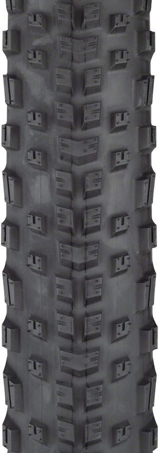 Close-up of a tire tread pattern with prominent knobs on a black background
