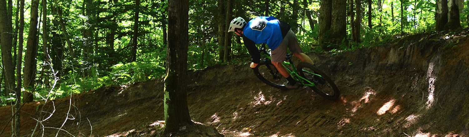 Riding an Upper Peninsula mountain bike trail with a burmed corner 