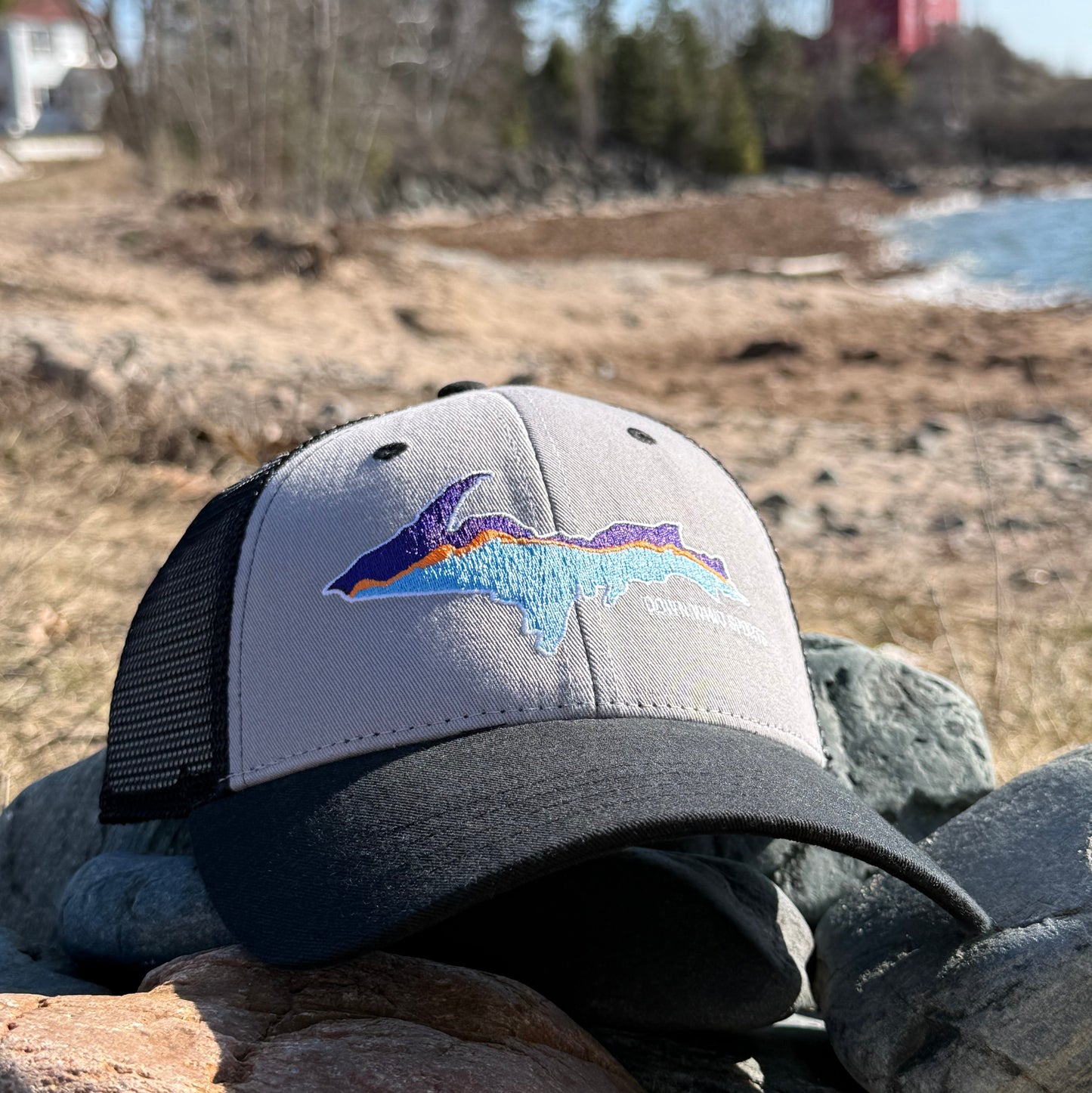 Gray cap with colorful logo on a stone wall
