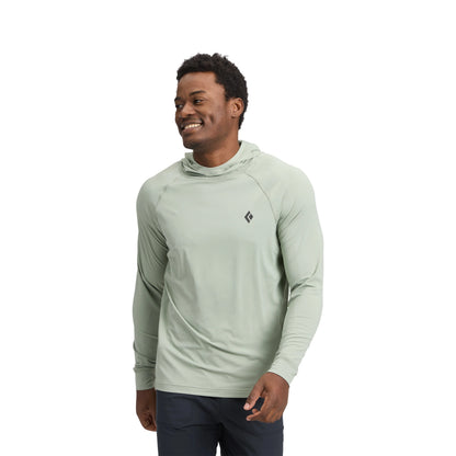 Man wearing a light green hoodie with a brand logo on a white background
