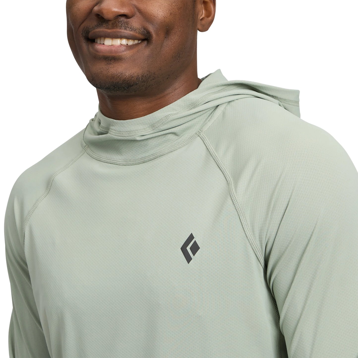 Person wearing a light green athletic hoodie with a brand logo on a white background