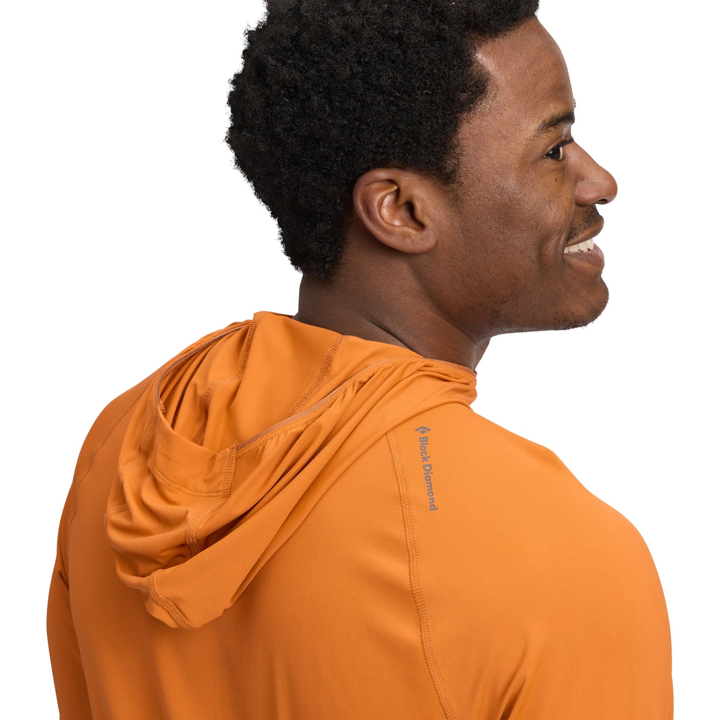 Man wearing an orange hoodie with a visible brand logo on a white background