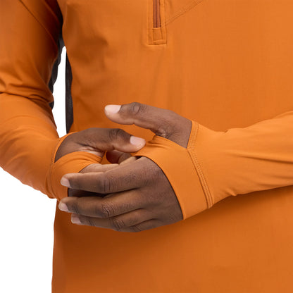 Close-up of a person wearing an orange jacket with gloves, focusing on the hands.
