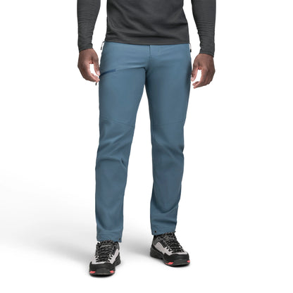 Person wearing blue pants and black shoes on a white background