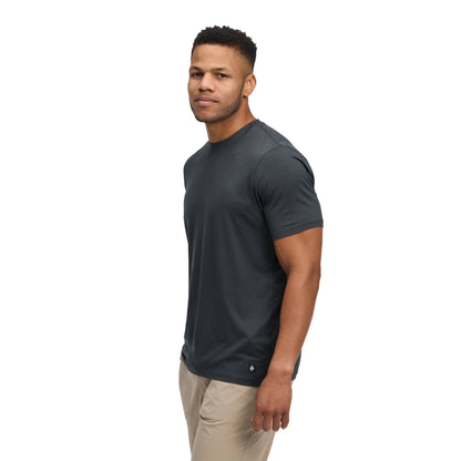 Man wearing a dark gray t-shirt and beige pants on a white background