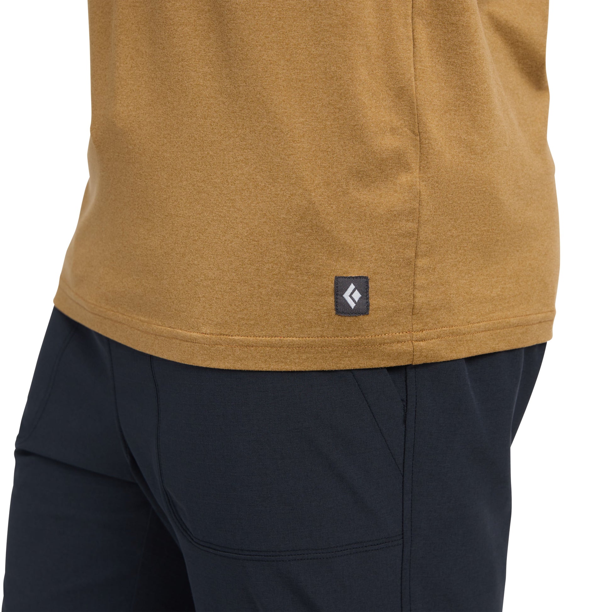 Close-up of a mustard yellow shirt with a Black Diamond logo and black pants on a white background