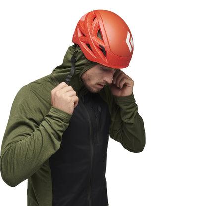 Person wearing a red helmet and green jacket on a white background