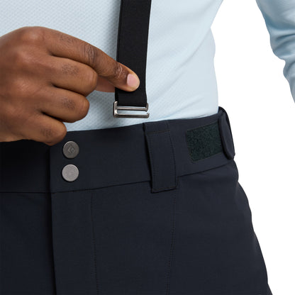 Person wearing navy pants with suspenders and a light blue shirt, focusing on the pants and suspenders.