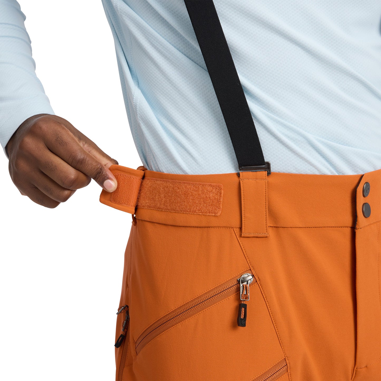 Person wearing orange pants with a focus on the waistband and zipper.