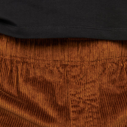 Close-up of brown corduroy pants with a black shirt underneath.