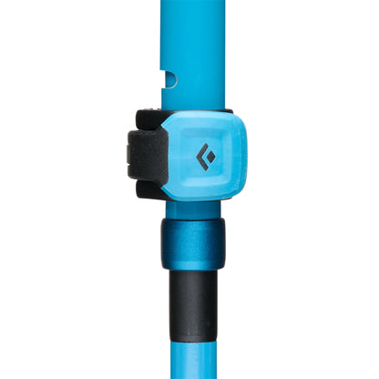 Close-up of a blue climbing device with a black clip on a white background