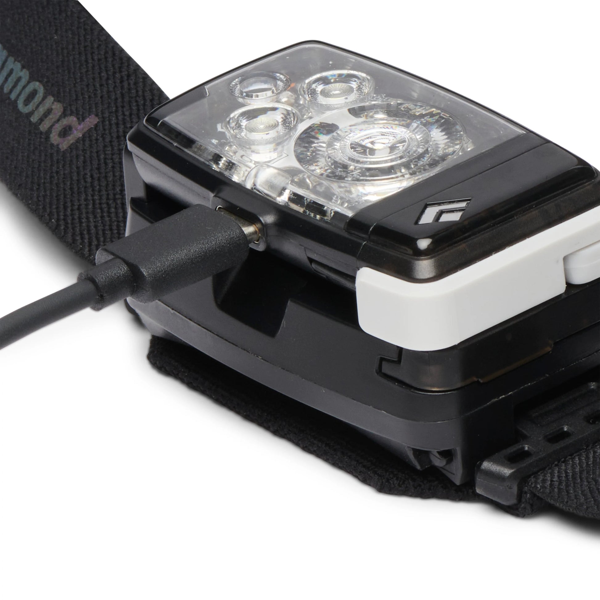 Black diamond headlamp charging on white background