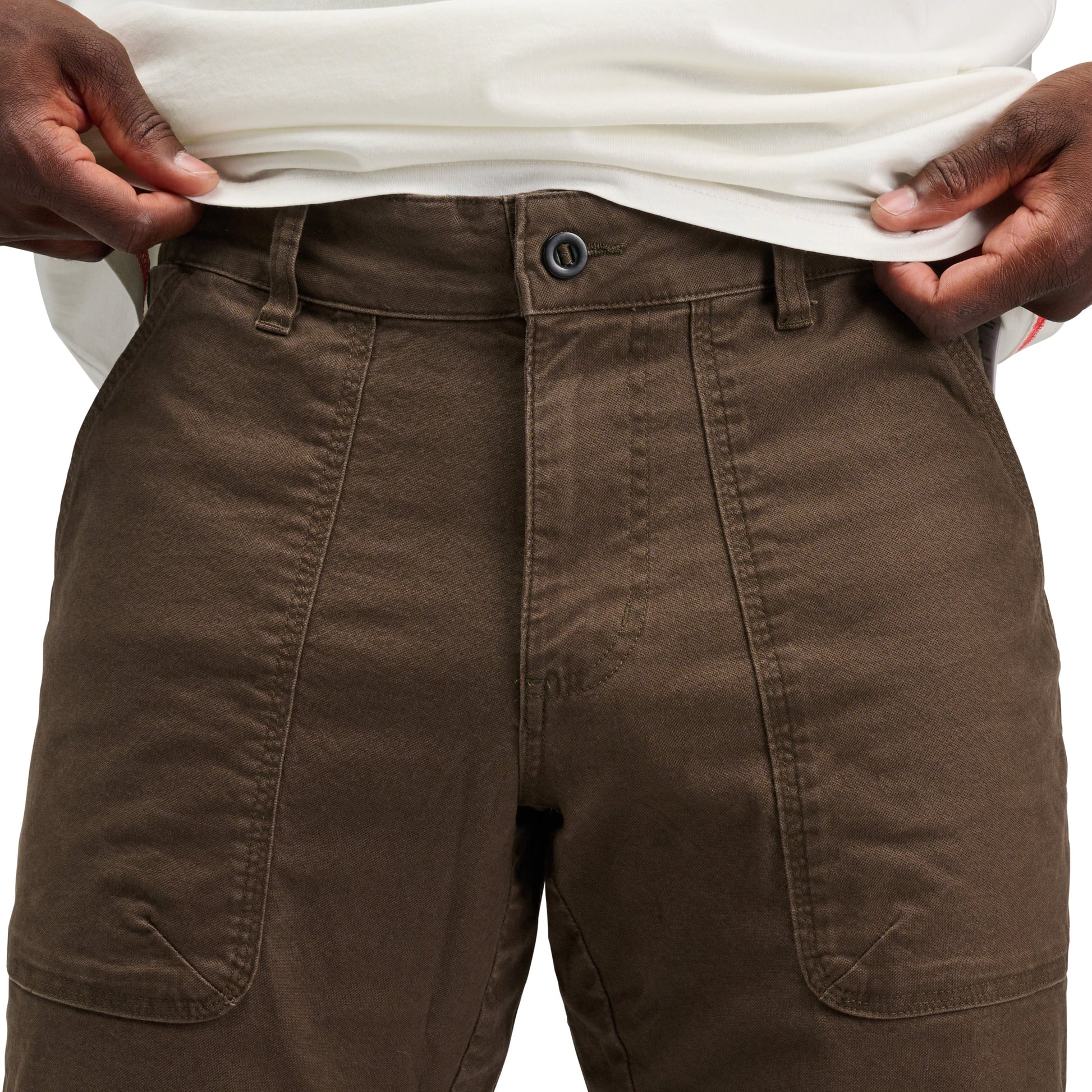 Brown pants being worn with a white shirt on a plain background