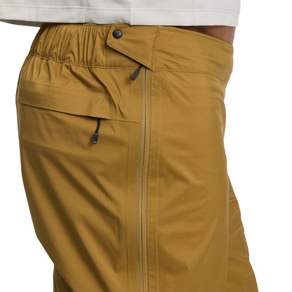 Close-up of mustard yellow pants with a white shirt underneath on a white background