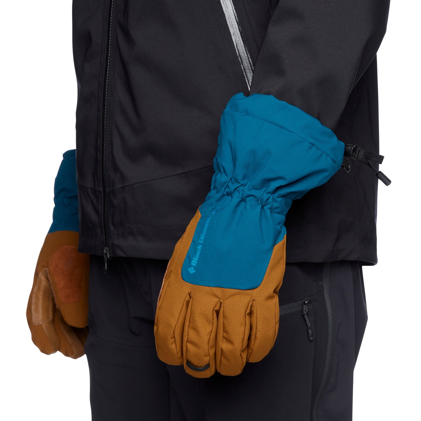 Blue and brown gloves worn with a black jacket on a white background