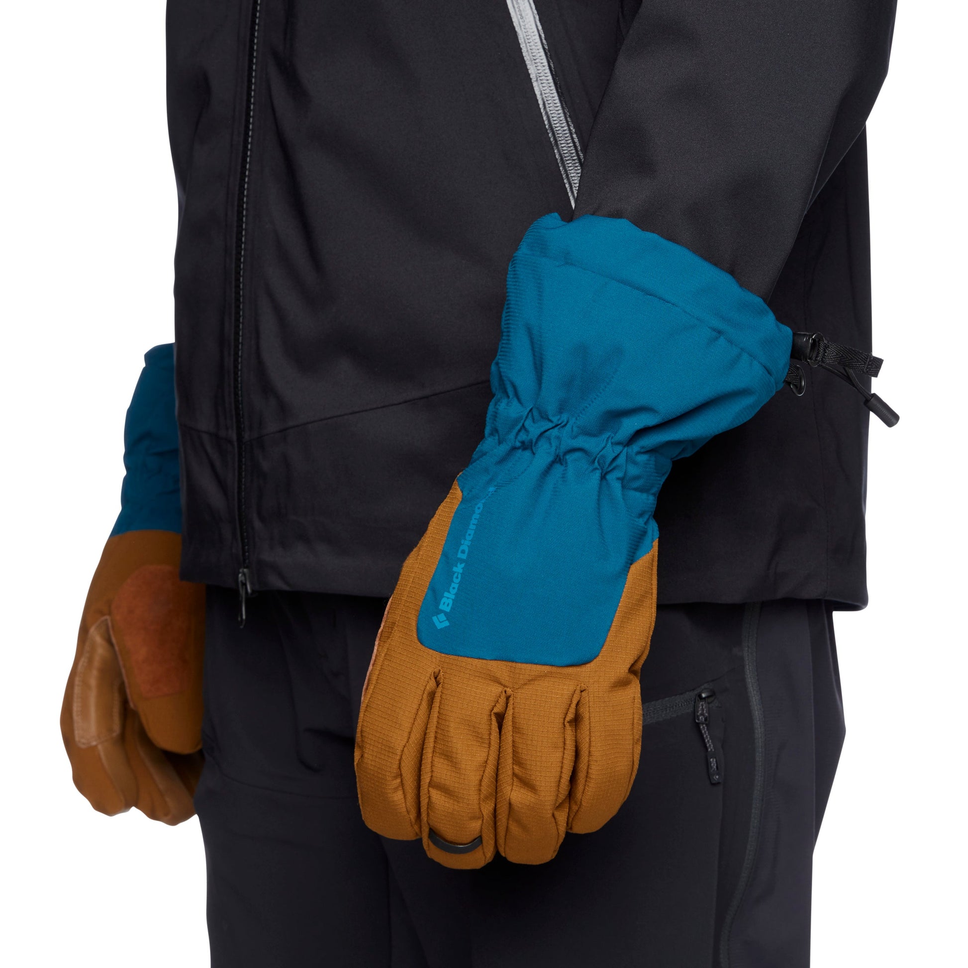 Blue and brown gloves worn with a black jacket on a white background