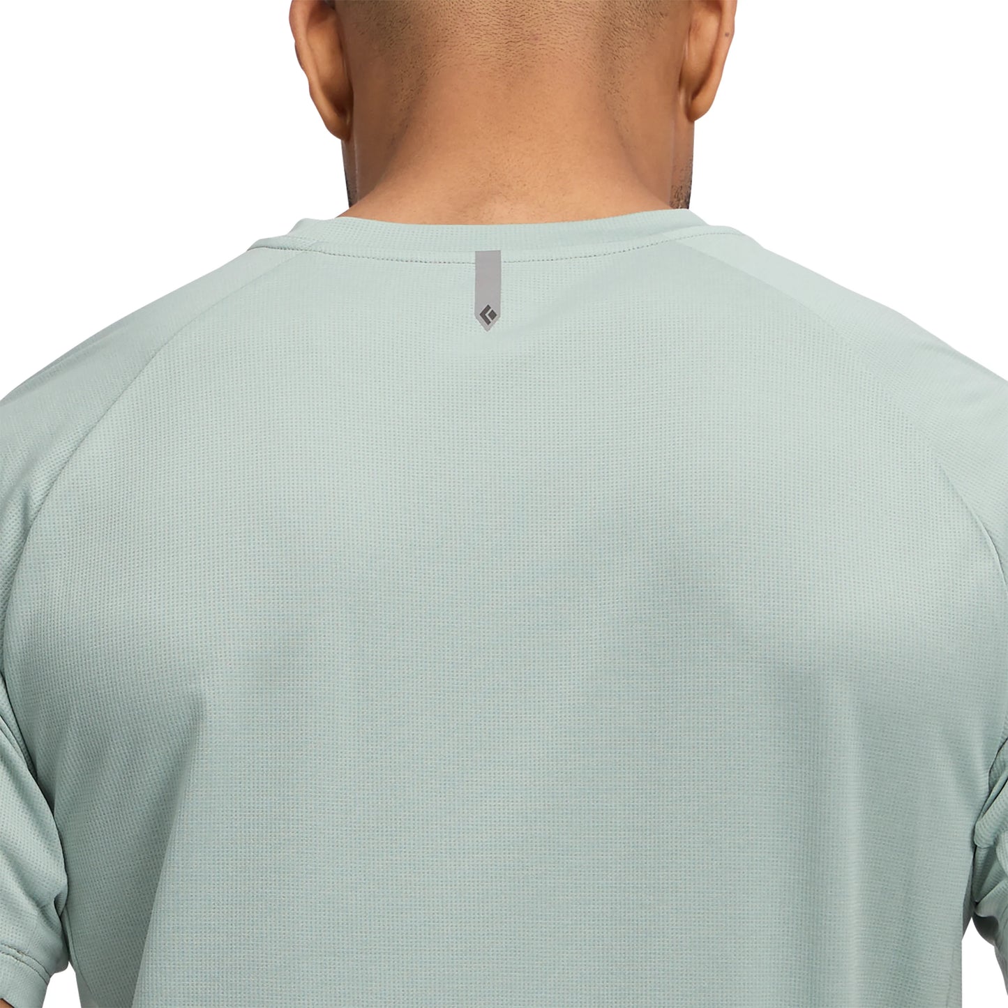 Light green athletic shirt worn by a person on a white background