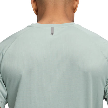 Light green athletic shirt worn by a person on a white background