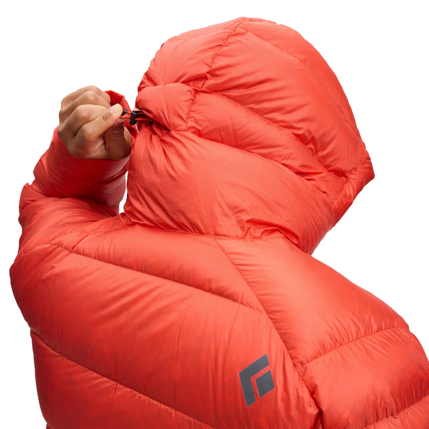 Person wearing a bright orange sleeping bag with a brand logo on a white background