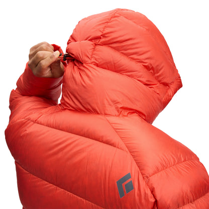 Person wearing a bright orange sleeping bag with a brand logo on a white background