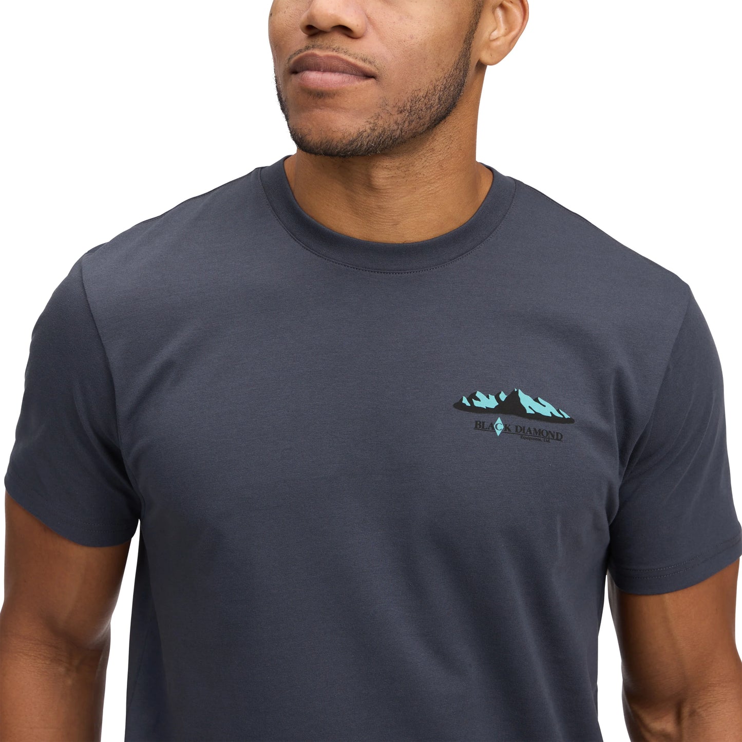 Man wearing a dark blue t-shirt with a logo on a white background