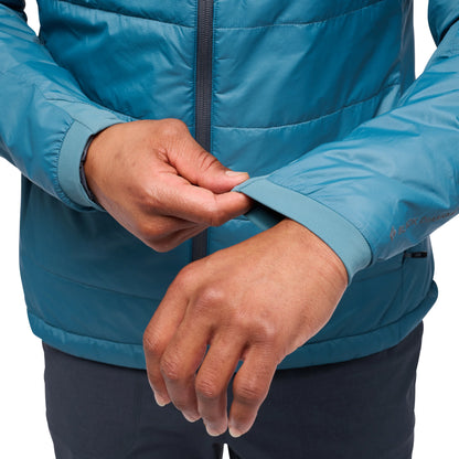 Close-up of a person wearing a blue jacket with hands adjusting the cuffs.