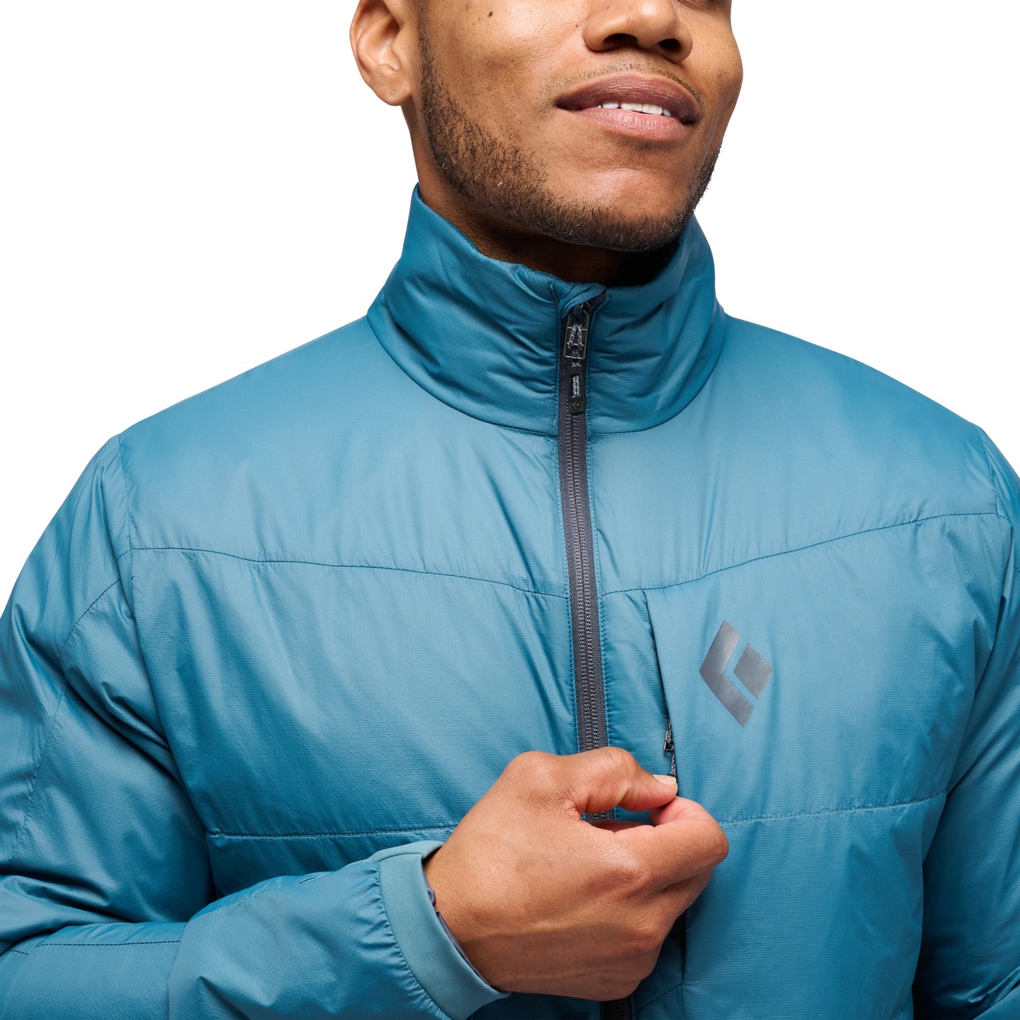 Person wearing a blue jacket with a brand logo on a white background