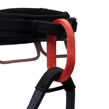 Close-up of a black chair with a red strap on a white background