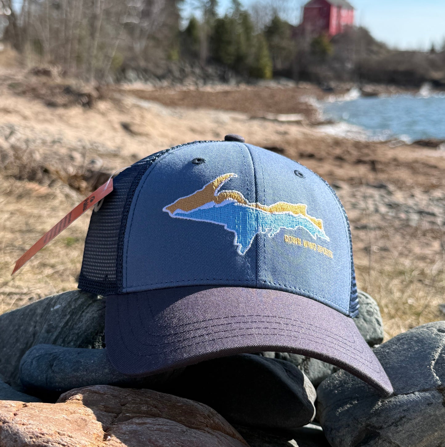 Blue cap with a logo on a rock wall.