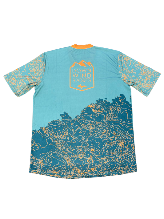 A short-sleeve athletic jersey shown from the back, featuring a light blue upper body, a dark teal lower body with yellow contour-line graphics, and a yellow 'Down Wind Sports' logo on the upper back.