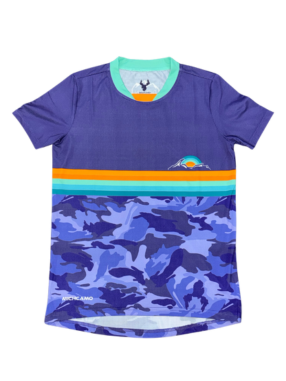 A short-sleeve athletic jersey in purple, featuring a horizontal stripe pattern with orange, teal, and light blue across the chest, and a blue and purple camouflage print on the lower half. The brand name 'MICHCAMO' is visible near the bottom left hem.