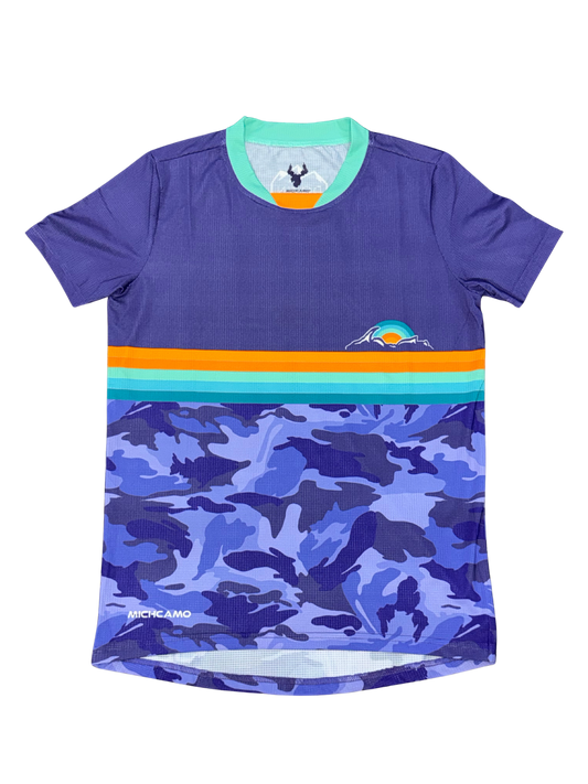 A short-sleeve athletic jersey in purple, featuring a horizontal stripe pattern with orange, teal, and light blue across the chest, and a blue and purple camouflage print on the lower half. The brand name 'MICHCAMO' is visible near the bottom left hem.