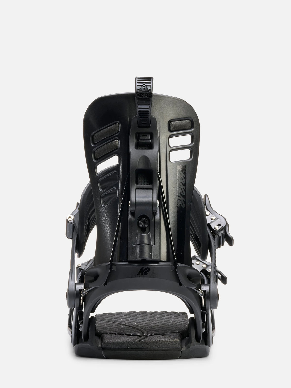 A single snowboard binding shown from the back on a light gray studio background. The binding is predominantly black with some gray and white branding details.