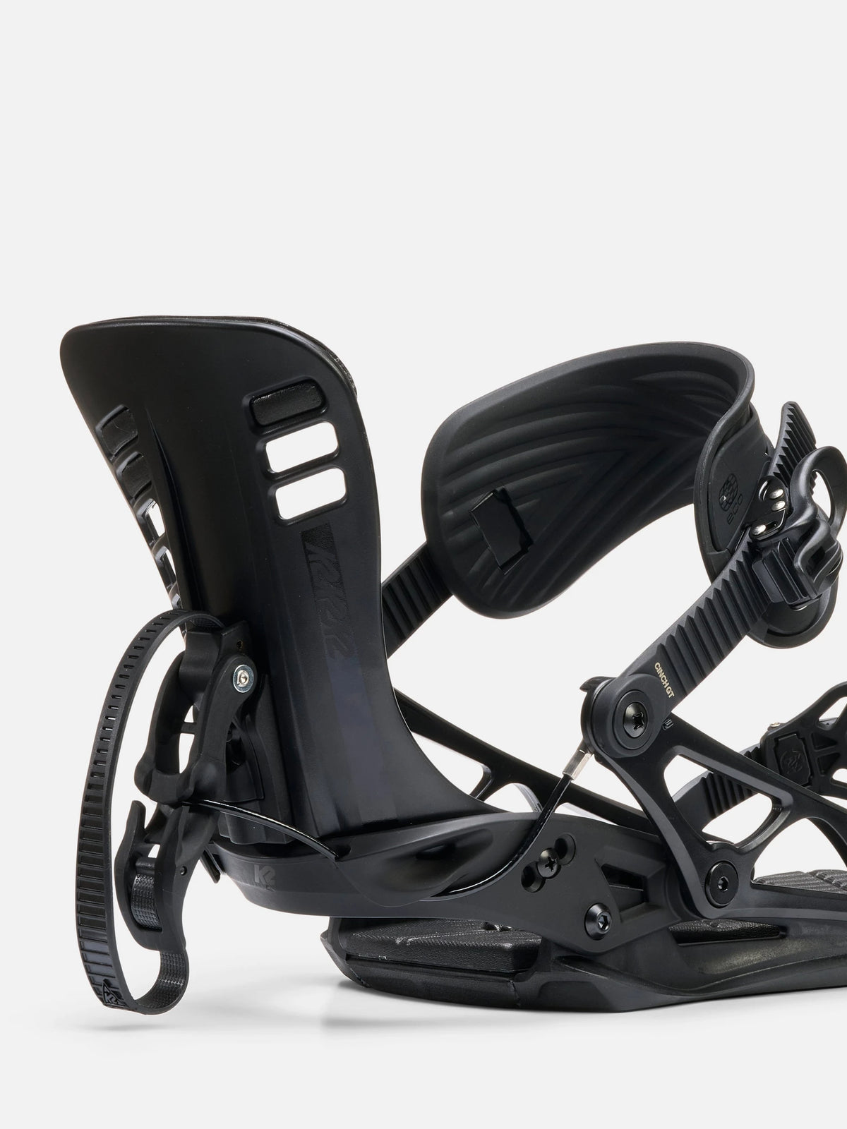 A close-up studio shot of a black snowboard binding on a light gray background.
