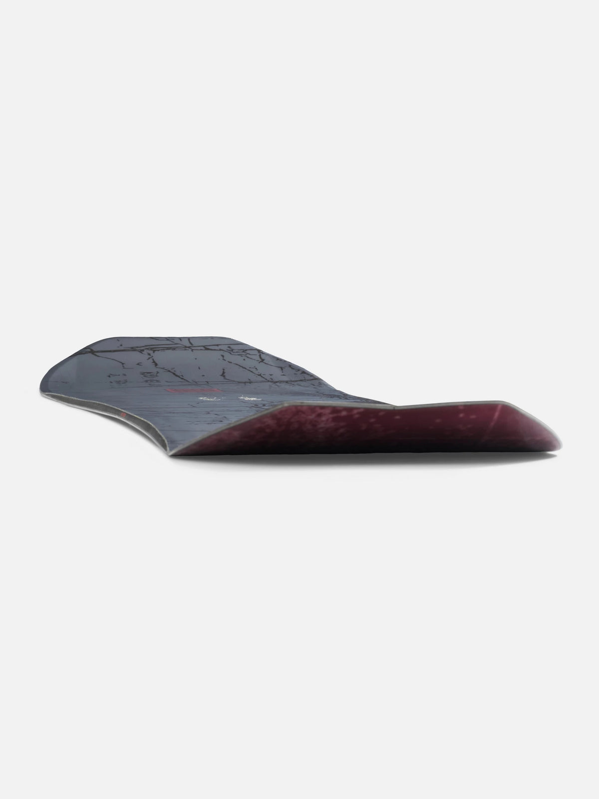 A curved snowboard shown from the side against a plain light gray background, featuring a dark gray top sheet and a deep burgundy wood base.