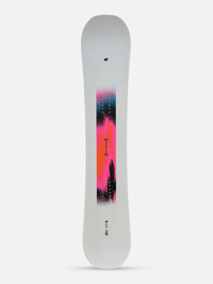 A snowboard shown from the base side against a light gray background, featuring a white base with a vibrant vertical graphic in pink, orange, and black.