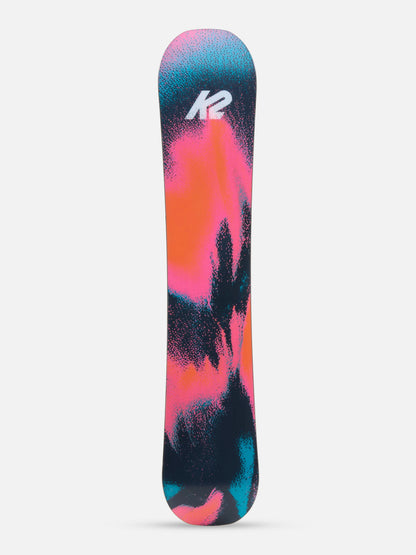 A K2 snowboard shown vertically against a light gray background, featuring a vibrant abstract design with pink, orange, teal, and black splatters, and the white K2 logo near the top.