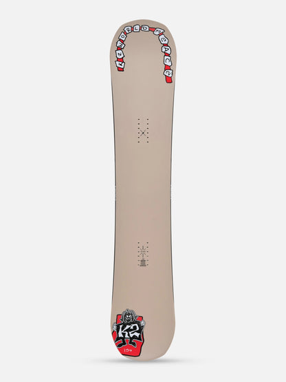 A snowboard shown from the base side, featuring a light beige background with red, white, and black graphics, including the 'K2' logo near the tail.
