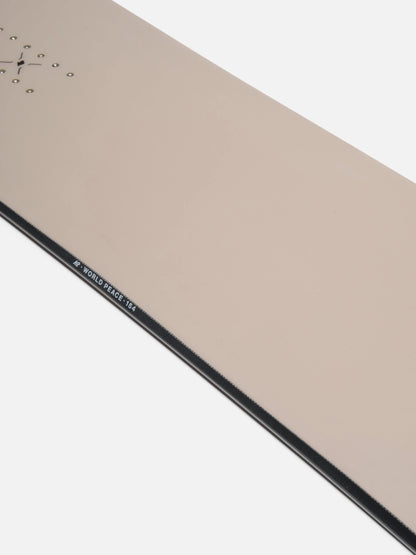 Close-up of a minimalist analog clock face in a warm beige or champagne tone, showing part of the black outer frame and small white text near the edge.