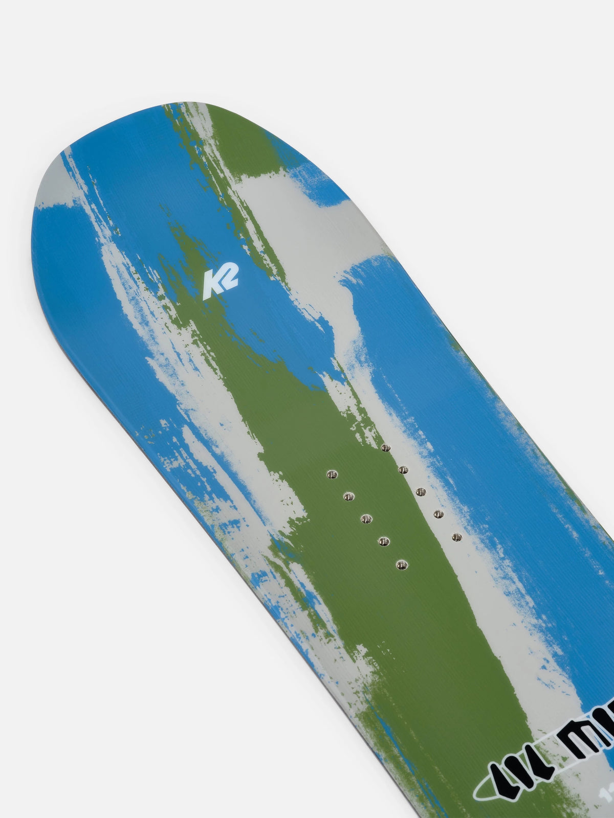 A close-up of a snowboard base showing a blue, green, and white abstract paint-splatter design with the K2 logo and binding mount holes visible.