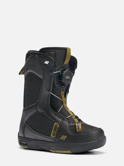 A black K2 snowboard boot with gold accents and a dial closure system, shown from a three-quarters angle on a light gray background.