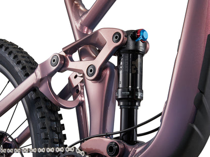 Close-up of a pink bicycle frame with suspension fork on a white background