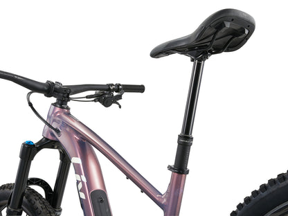 Close-up of a bicycle with a pink frame and black seat on a white background